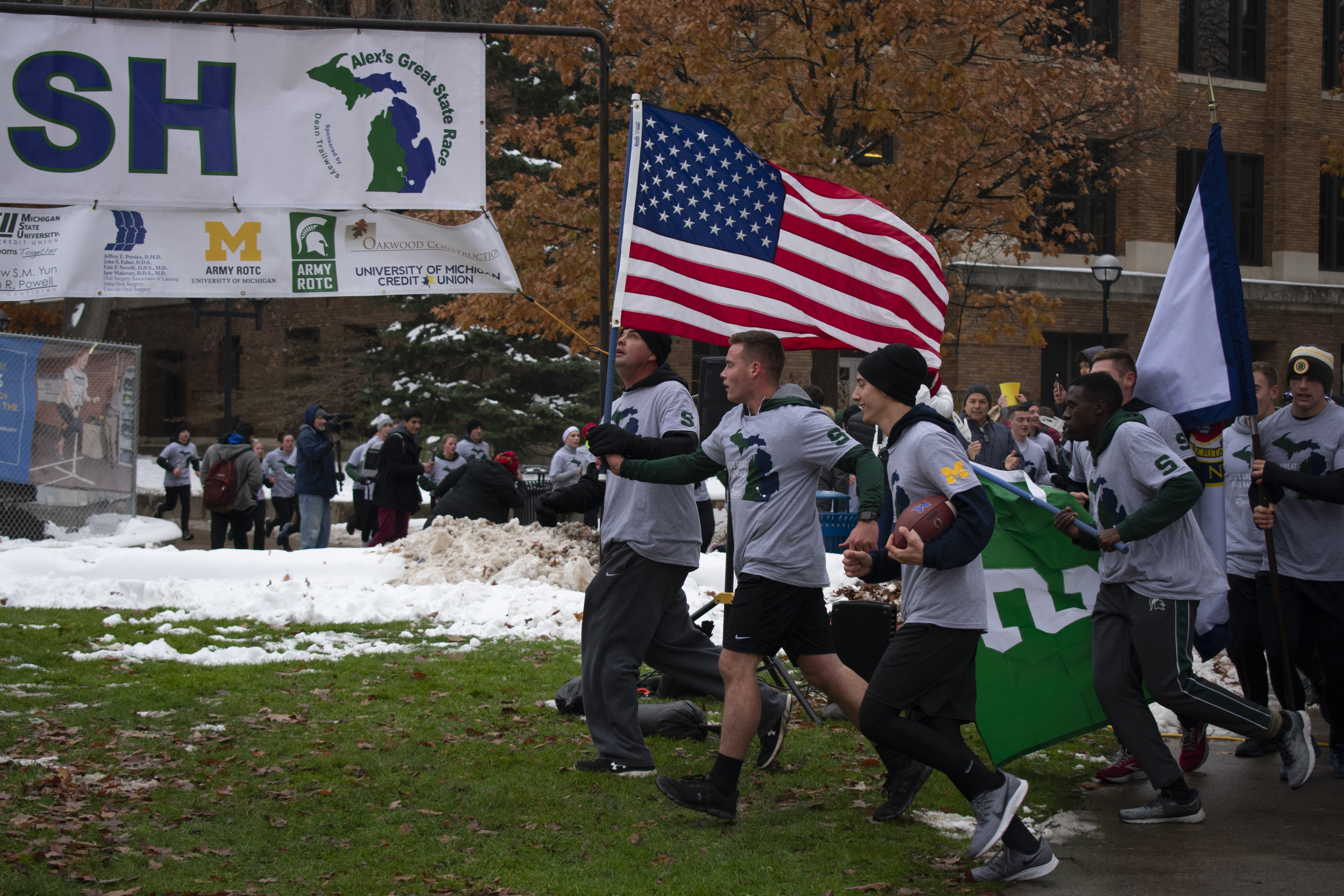 ROTC from U of M and MSU running under the finish line